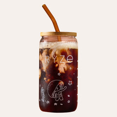 RYZE branded glass coffee can with bamboo lid and amber straw, filled with iced dark mushroom coffee